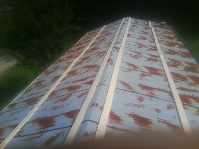 Rusted metal roof panels with new wood purlins before replacement — Storm Damage Roof Repair in Fort Washington by Roofing Brothers
