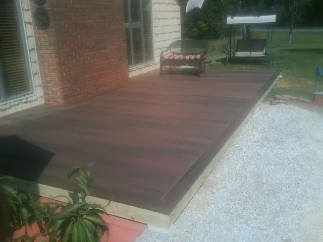 Freshly stained wood deck built against a brick home in Fort Washington
